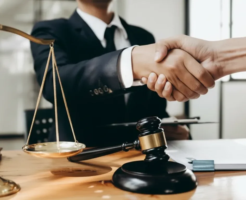 Lawyer shaking hands with a client, symbolizing trust and partnership in legal services, with a gavel and scales of justice on the table, representing law firm marketing and client acquisition strategies.