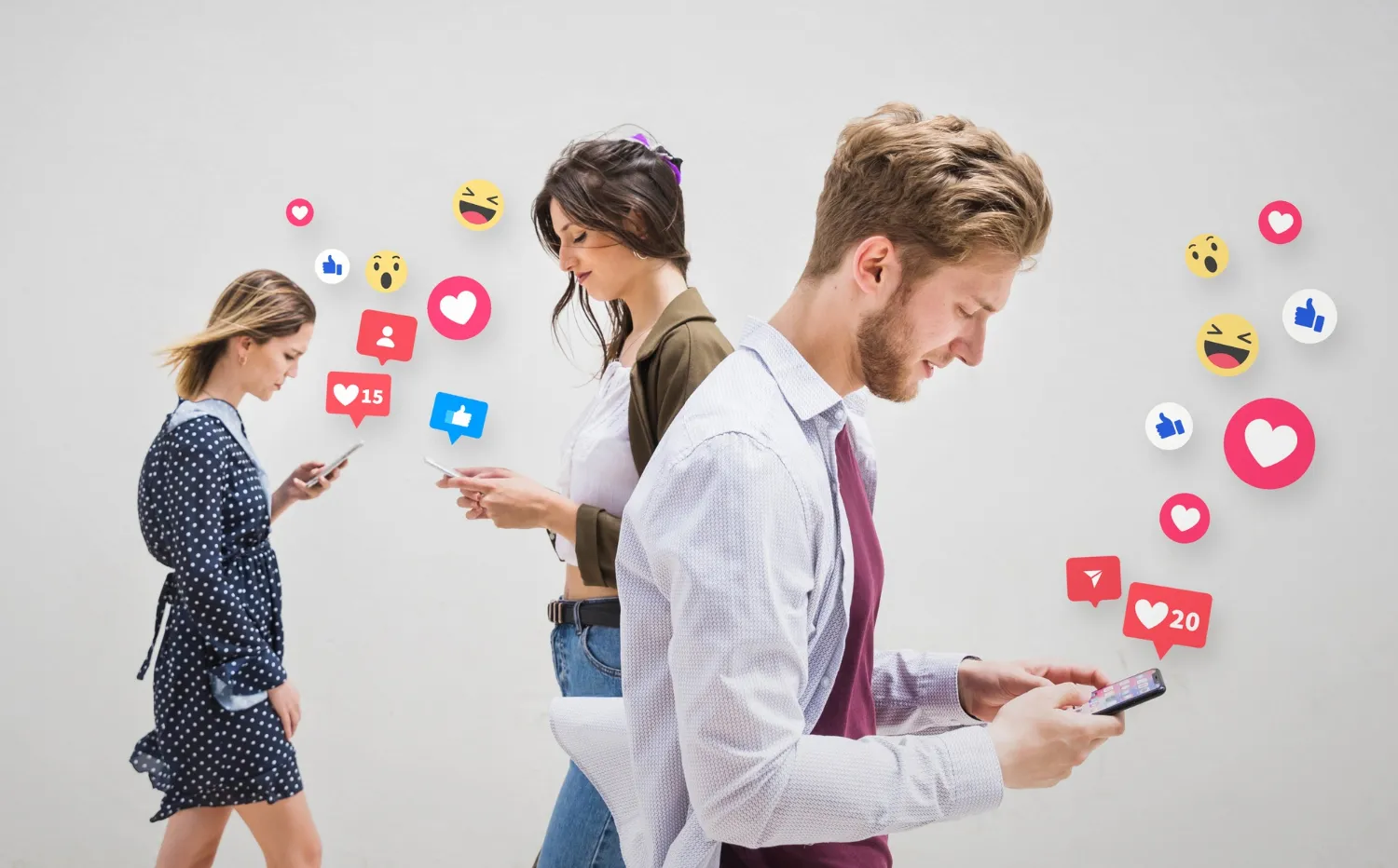 Three young adults looking at their smartphones surrounded by floating social media notification icons like likes, comments, and emojis.